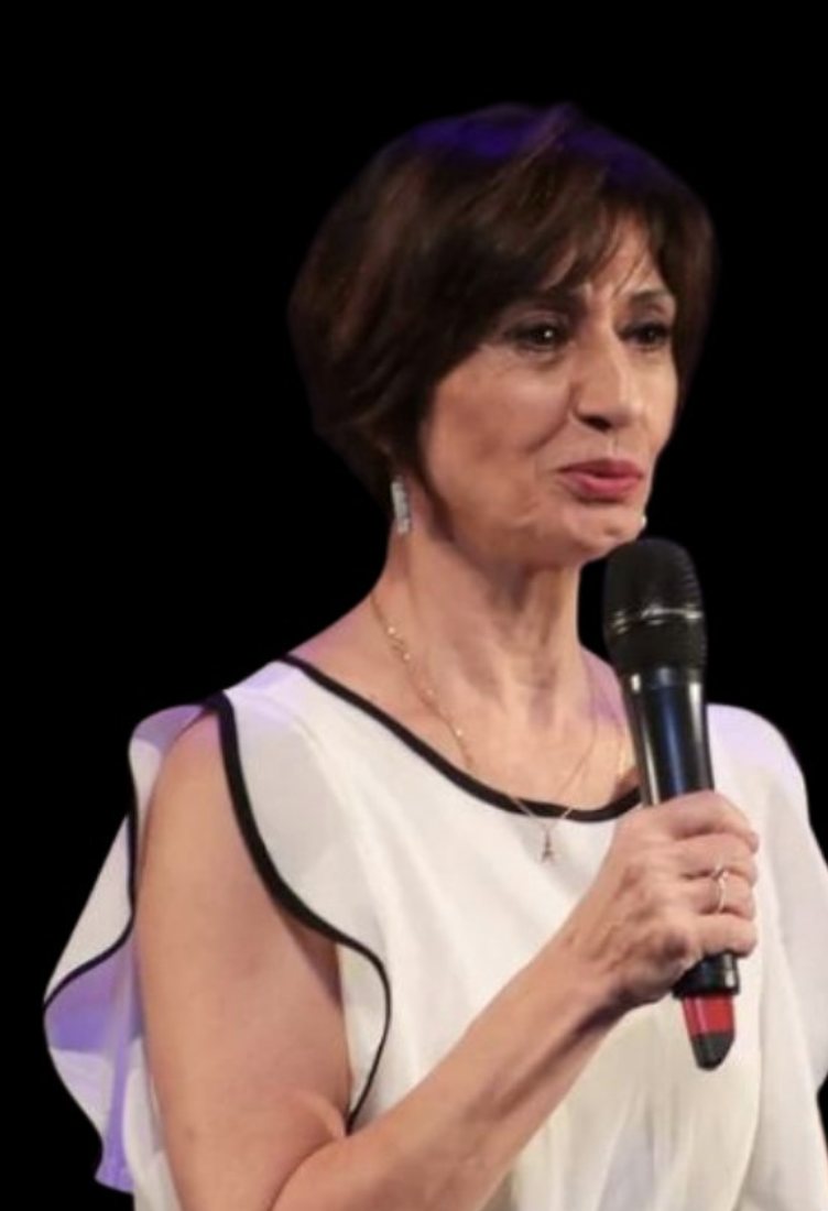 Gisele Bellot falando ao microfone no palco
